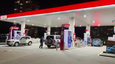 Esso benzin istasyonunda 4K çözünürlüklü birkaç arabanın gece görüntüsü..