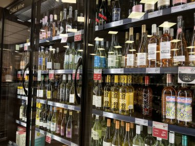 Coquitlam, BC, Kanada - Haziran 2024: BC Liquor mağazasındaki buzdolabında üzüm şarabı şişelerinin satışını göster.