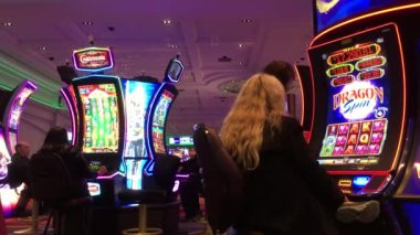 Kumarhane içinde slot makinesiyle oynayan insanların hareketleri 4k çözünürlüklü