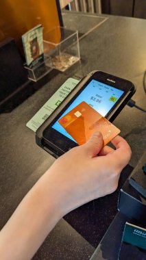 Starbucks 'ta kahve ödemek için kredi kartı kullanan bir kadın.