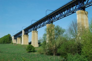 Eisenbahnbruecke aus Stahl mit weissen Betonpfeilern