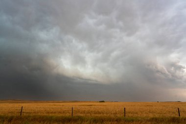 Bir alan üzerinde yaklaşan süper hücre fırtınası dramatik ve uğursuz bir atmosfer yaratıyor.