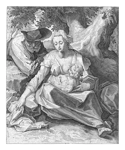 マリアは裸で座り キリストの子は木のそばで膝をつき ヨセフは右肩で切り株の上にもたれる 公演の下に2行のラテン文字 — ストック写真