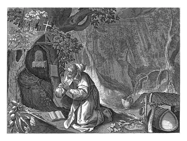 或者是荒野中的隐士下雨了或者跪在圣经和十字架前 右边是一间有玛丽亚标志的茅屋 — 图库照片