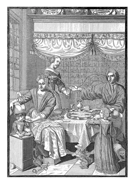 在荷兰内陆 一家人坐在一张定好的桌旁 桌上有一碗鱼 盘子和眼镜 一个女佣倒了一杯 家长们坐着 一个孩子站在桌旁 — 图库照片