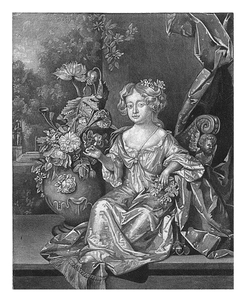 Anne Windham as a child. She is sitting next to a vase of flowers. In the background a garden.