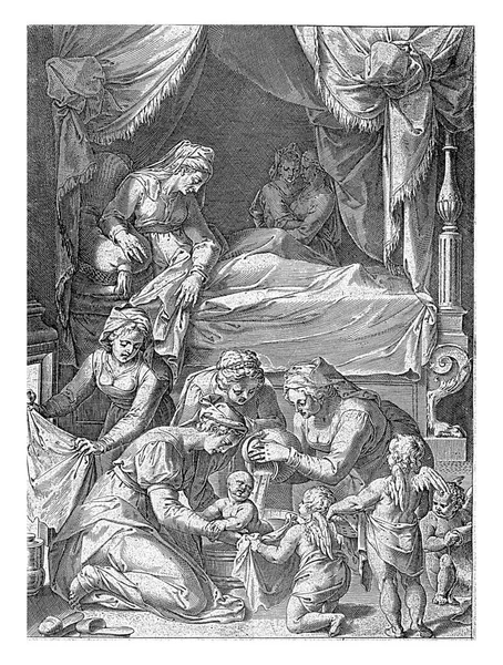 安娜躺在一张有四张海报的床上 看着妇女们在前排为她的孩子洗澡 左边是一个女人在炉前暖着布 前面是三个拿着毛巾的天使 — 图库照片