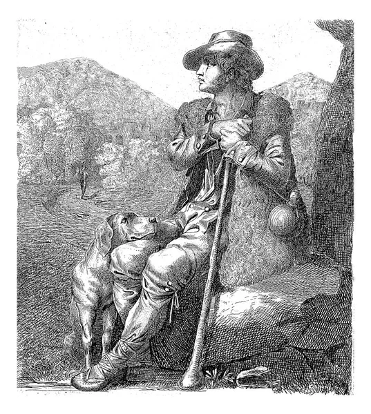 風景の中で 羊の皮で身を包んだ羊飼いが岩の上の木の下に座っている 羊飼いの横には 若い男の膝の上に頭を休める犬が座っている — ストック写真