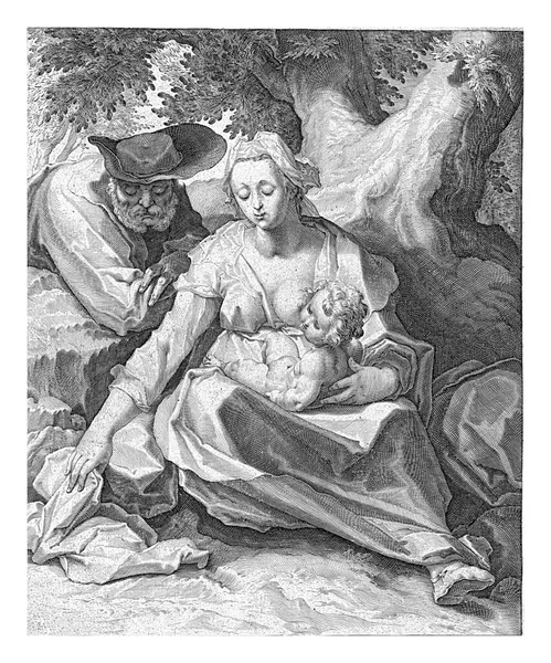 马利亚赤身裸体地坐着 基督的孩子在她腿上的一棵树旁 约瑟靠着她的右肩靠在树桩上 在执行部分下面是两行拉丁文文本 — 图库照片