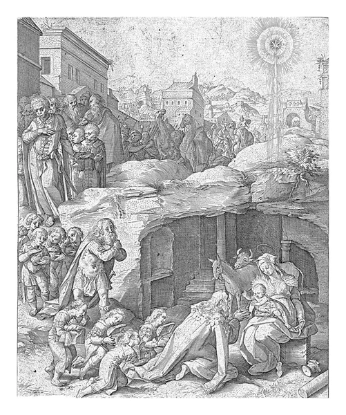 メアリーは膝の上にキリストの子と洞窟の前に座っている 王とその従者で構成される行列は 背後の都市の門を通過します ラテン語の印刷八行下の余白に — ストック写真