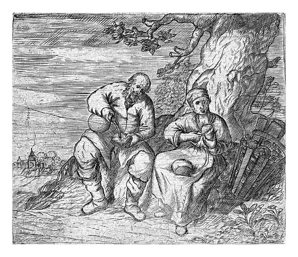 男と女が木の下に座り 食事をする 女はパンを切り 男はボウルに何かを注ぐ — ストック写真