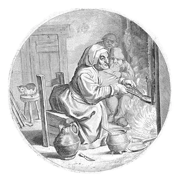 一个女人坐在室内的火堆前烤煎饼 她身后的两个男孩和左边的一只猫在凳子上 — 图库照片