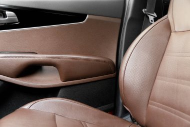 Modern lüks araba kahverengi deri iç döşeme. Kahverengi delikli deri koltuğun beyaz dikişli kısmı. Prestij arabasının içi. Rahat delinmiş deri koltuklar. Delinmiş deri..