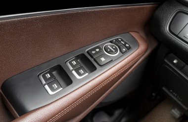 Lüks bir yolcu vagonunun güç kontrol düğmeleri olan kapı kolu. Kahverengi, iç kısmı dikişle delinmiş. Modern araba turuncu deri iç döşeme ayrıntıları.