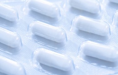 Beyaz arka planda izole edilmiş gümüş kabarcık ambalaj içinde Macro shot tablet yığını. Alüminyum folyo su topladı. Eczane ürünleri. İlaç hapları ve uyuşturucular kapanıyor. Haplar arka plan