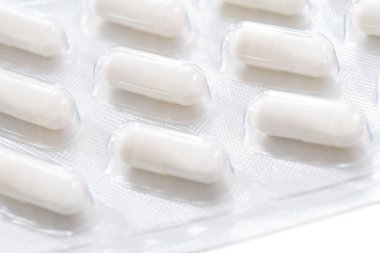 Beyaz arka planda izole edilmiş gümüş kabarcık ambalaj içinde Macro shot tablet yığını. Alüminyum folyo su topladı. Eczane ürünleri. İlaç hapları ve uyuşturucular kapanıyor. Haplar arka plan