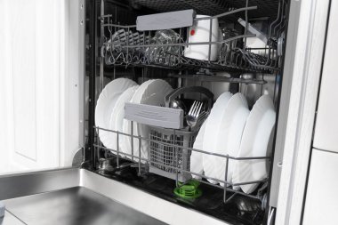 Bulaşık makinesinin iç rafları ve çatal bıçak takımı için bir sepet dağıtımı için. Yepyeni Açık bulaşık makinesi yakın çekim. Kuru çatal bıçak takımı yakın çekim