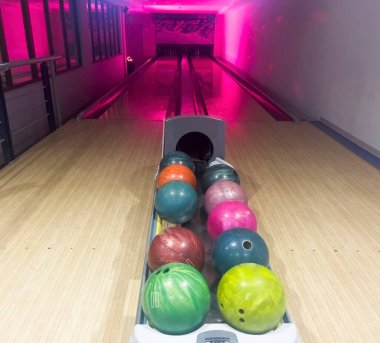 Bowling şeridi. Bowling salonundaki raflardaki birkaç bowling topunun arkaplan görüntüsü. Bowling pisti yolları