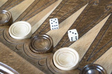 Closeup of backgammon board game. Wooden backgammon board with checkers and dice pair