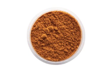 Curry powder in round white bowl isolated on white background. Top view.