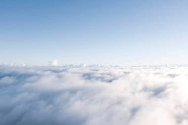 Aerial view White clouds in blue sky. Top. View from drone. Aerial bird's eye. Aerial top view cloudscape. Texture of clouds. View from above. Sunrise or sunset over clouds