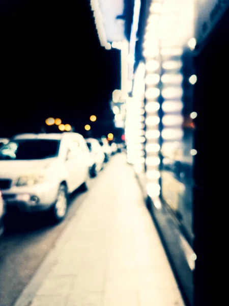 背景がぼやけている 夜の街 建物の燃えるようなシルエット 輝く提灯のボケスポット 街の通りのぼやけた景色 街路灯のぼんやりとしたぼんやりとした夜の街 — ストック写真