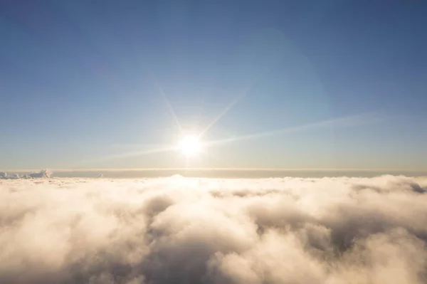 Aerial view White clouds in blue sky. Top. View from drone. Aerial bird\'s eye. Aerial top view cloudscape. Texture of clouds. View from above. Sunrise or sunset over clouds