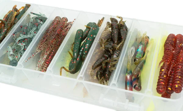 Jig silicone fishing lures in plastic tackle lure box. Silicone fishing baits isolated. Colorful baits. Fishing spinning bait. Silicone soft plastic bait lure