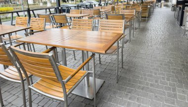 Bir Avrupa şehrinde boş, şık bir sokak kafesi. Sokak restoranı. Teraslı. Boş kafe masaları ve sandalyeler. Kafe restoranının dışında.