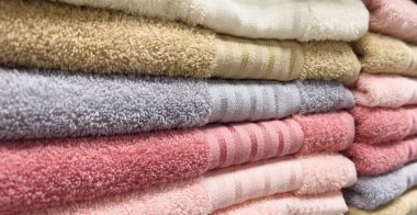 Stack of colorful towels. Fresh new fluffy towels. Pile stacked colored fabric towels. Stack colored cotton towels