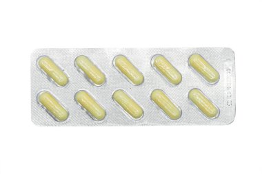 Beyaz arka planda izole edilmiş gümüş kabarcık ambalajında sarı haplar yığını. Alüminyum folyo su topladı. Eczane ürünleri. İlaç hapları ve ilaçlar. Haplar arka plan