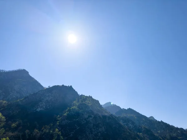 stock image Scenic aerial mountain view to green forest valley in sunlight among mountain ranges and hills on horizon. Green landscape with sunlight mountains.