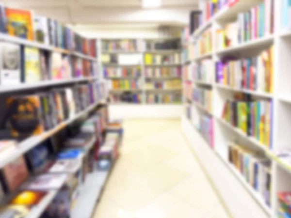 Abstract blurred modern white bookshelves with books. Blur manuals and textbooks on bookshelves in library or in book store. Concept for education. Library interior bokeh background.