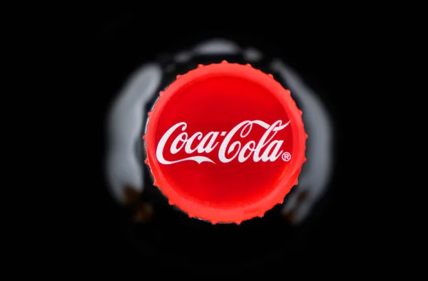 亚美尼亚埃里温 2023年5月10日 可口可乐标志在瓶塞瓶盖上 黑色可乐瓶闪烁着水 顶部视图 经典公司标志 — 图库照片