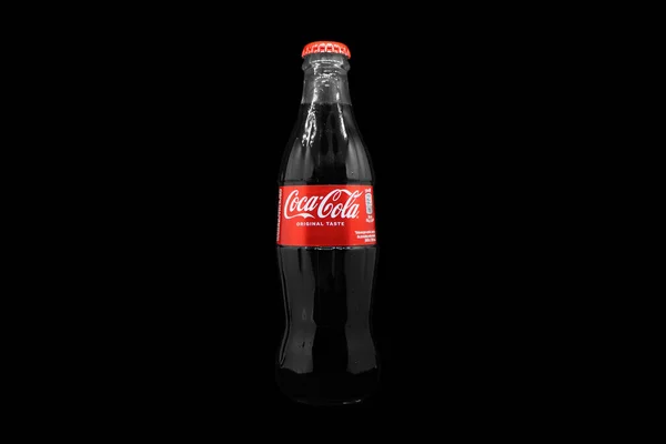 亚美尼亚埃里温 2023年5月10日 可口可乐标志在软木塞盖上 黑色玻璃瓶可口可乐闪耀的水 经典的公司标志 一壶可乐站在黑桌上 — 图库照片