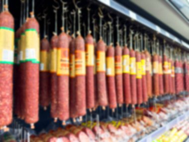 Çeşitli et ürünleri içeren bulanık arka plan gösterimi. Mavi et farklı renk ve boyutlarda tütsülenmiş lezzetler. Ev yapımı et lezzetleri.