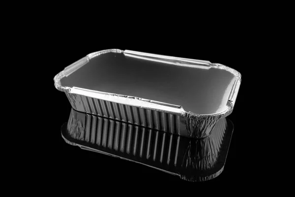 在黑色背景上隔绝的烘烤盘的折叠特写 用黑色隔离的空的即弃方铝箔烘烤盘 — 图库照片