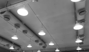 Işıklar ve havalandırma sistemi sanayi binasının tavanında uzun bir sıra halinde. Sergi Salonu. Tavan fabrikası inşaatı