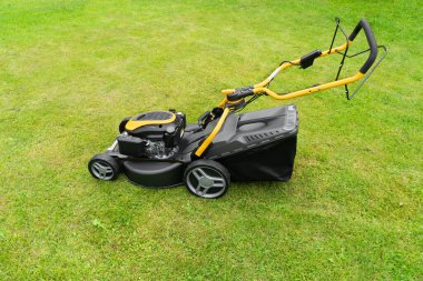 Çim biçiyorum. Çim biçme makinesi. Çim biçme ekipmanı. Bahçıvan bakım aracı yakın görünüm biçme. Yumuşak ışıklandırma