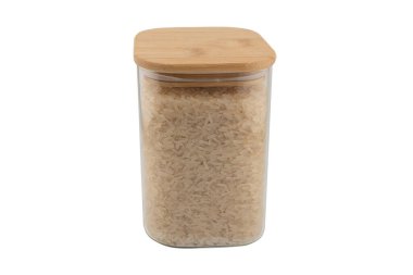 Beyaz arka planda izole edilmiş cam kavanozdaki pirinç. Cam saklama kavanozundaki çiğ organik pirinç taneleri izole edilmiş..