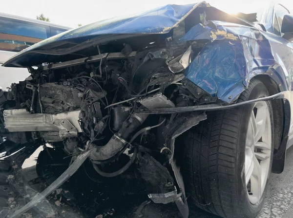 A blue car crashed accident. Car accident on the road. Car crash accident on street. Damaged vehicle. Car insurance concept. Vehicle get big damage by accident on the road.