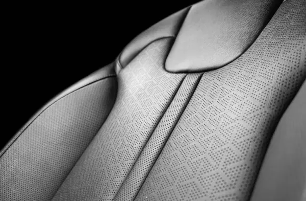 Car black leather interior. Part of black leather car seat details with white stitching. Interior of prestige car. Perforated leather seats isolated. Perforated leather.