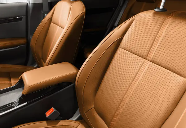 Brown luxury modern car Interior. Detail of modern car interior. Part of brown leather seats with red stitching in expensive car
