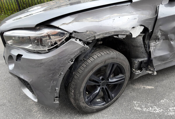 A grey car crashed accident. Car accident on the road. Car crash accident on street. Damaged vehicle. Car insurance concept. Vehicle get big damage by accident on the road.
