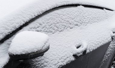 Donmuş araba. Araba kar ve buzla kaplı. Şiddetli bir kar yağışı sonrası arabanın bir kısmı kar altında kalmış. Kar fırtınasından sonra arabanın vücudu karla kaplıdır.