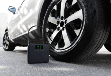 Hava kompresörü. Taşınabilir pompa otomatik hava kompresörü izole edildi. Manometresi olan elektrikli hava kompresörü. Taşınabilir kablosuz lastik enflasyonu. Taşınabilir hava pompasıyla şişirilmiş araba lastiği.