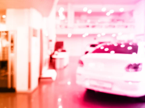Blurred background with car dealership store interior. Blurred abstract dealership store with defocused cars. Blur bokeh transportation concept dealer showroom background