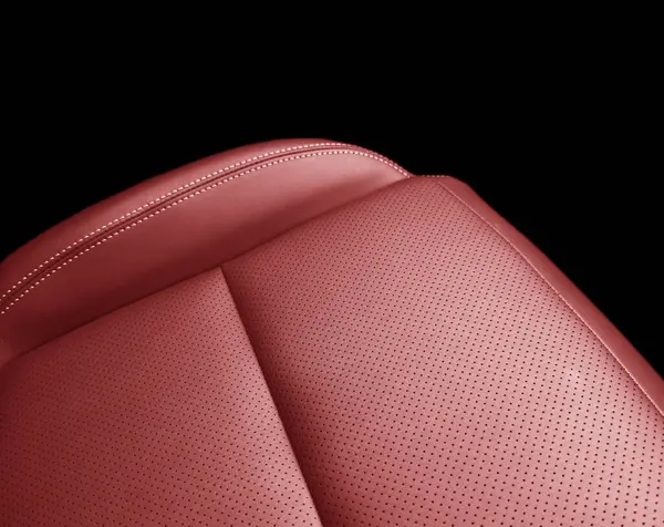 Car red leather interior. Part of red leather car seat details with white stitching. Interior of prestige car. Perforated leather seats isolated on black. Perforated leather.