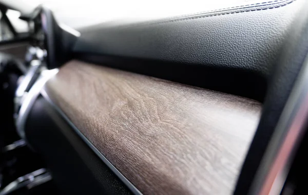 Car black leather interior with natural wood panel. Interior of prestige modern car. Black perforated leather. Car inside