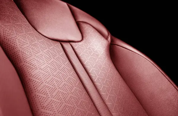 Car red leather interior. Part of red leather car seat details with white stitching. Interior of prestige car. Perforated leather seats isolated. Perforated leather.